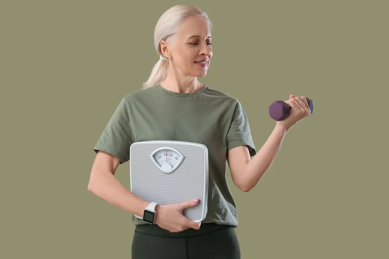 Sporty mature woman with scales and dumbbell on green background